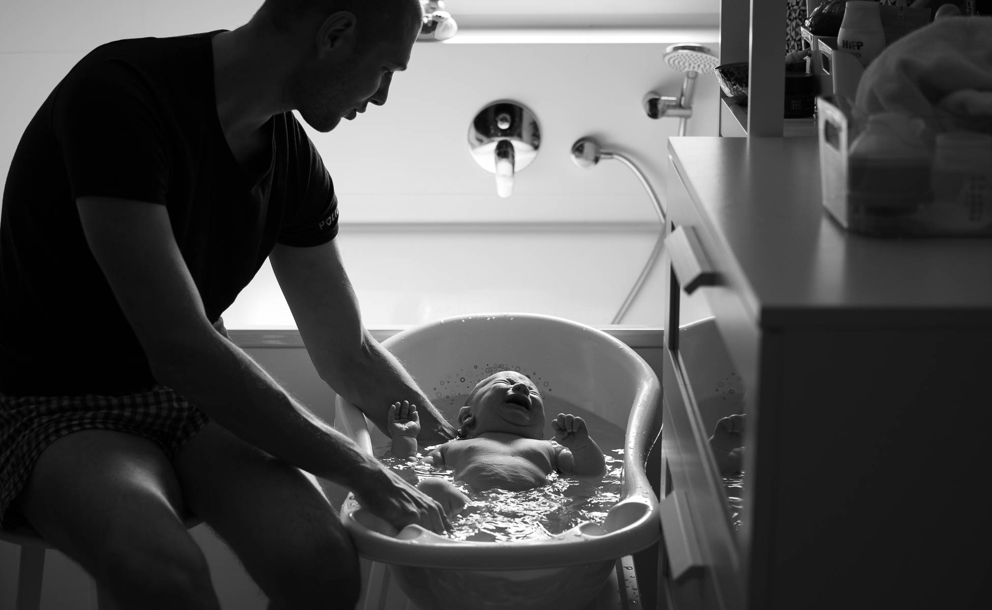 Vater badet Baby, Baby weint - Natürliche Familienfotos dokumentarische Familienfotografie -