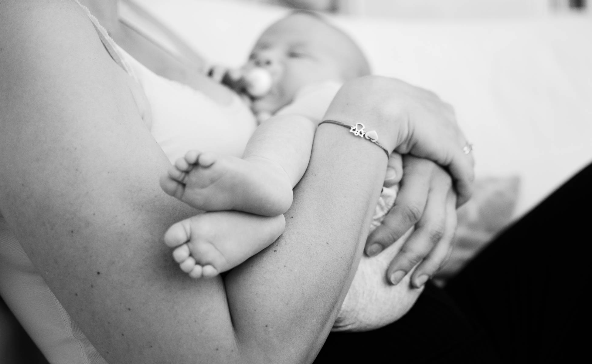 Baby schläft in den Armen der Mutter