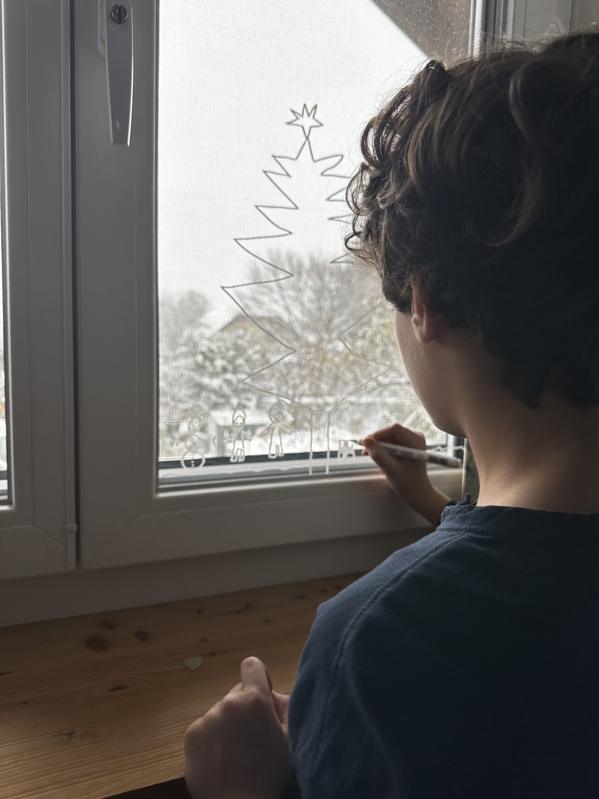 Kreative Winterzeit – Kinder dekorieren Fenster mit Maria Lea Maria Lea Familienfotografie: Kind beim Dekorieren von Fenstern mit winterlichen Mustern