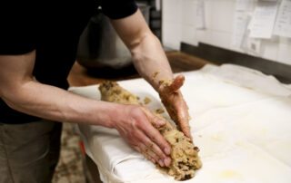 - Businessfotografie, Businessreportage, Businessshooting. Konditorlehrling macht Apfelstrudel von Hand