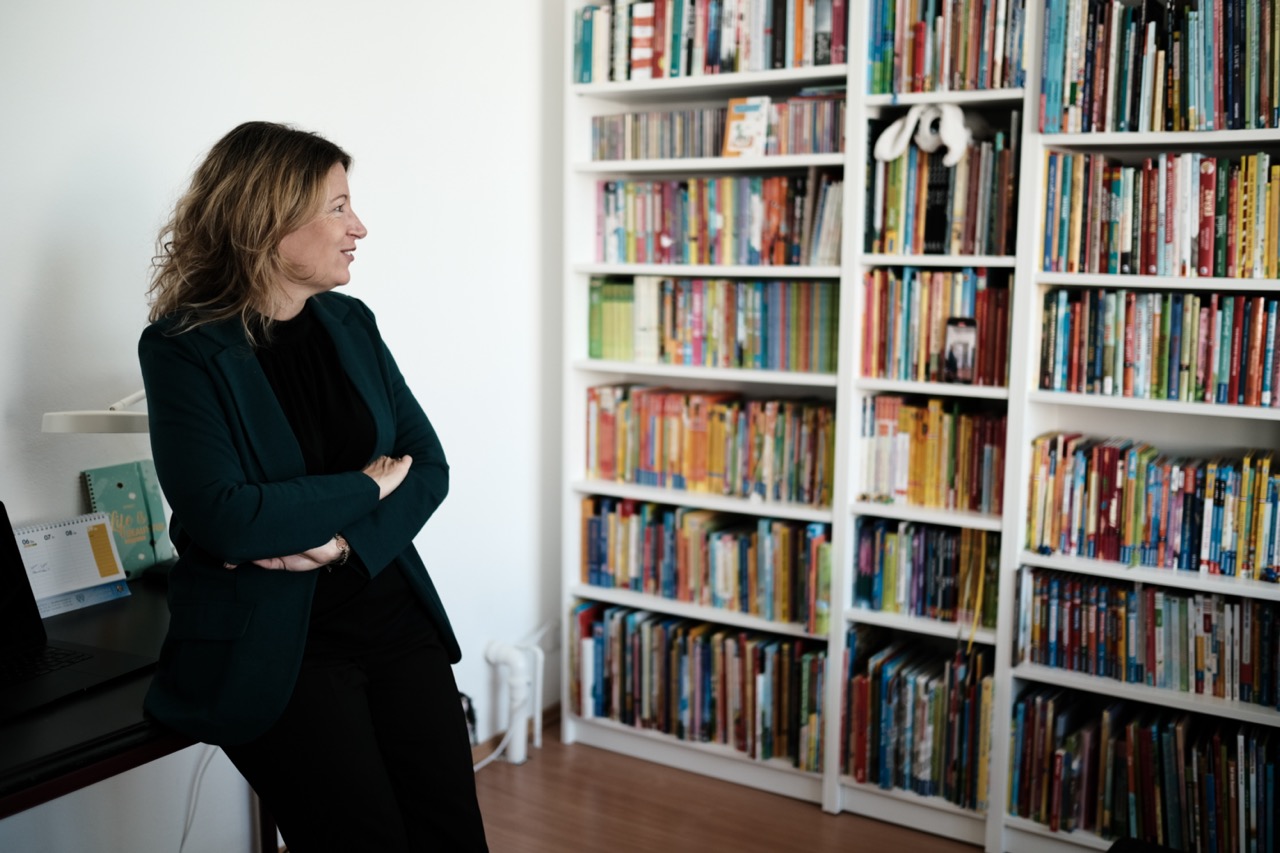 Gründerin der Oase blickt zum Bücherregal
